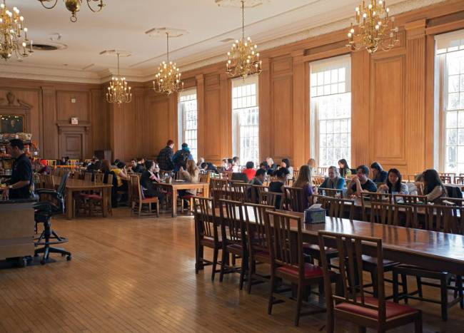 students eating on tables in a dining hall