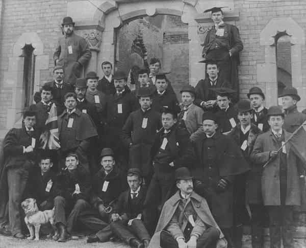 Group of about 30 men, and a small bulldog, in front of University College
