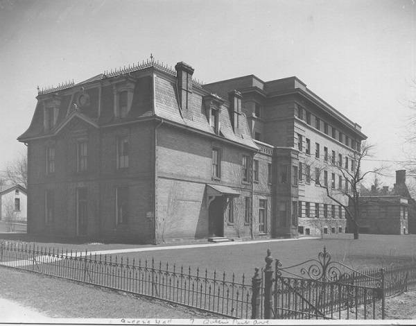Exterior of building with lawn and wrought iron fence