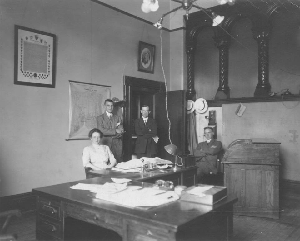 one woman and three men in an office