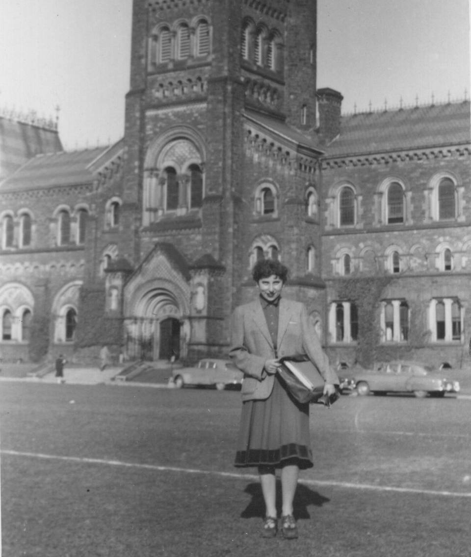 Woman standing on grass with University College in the background