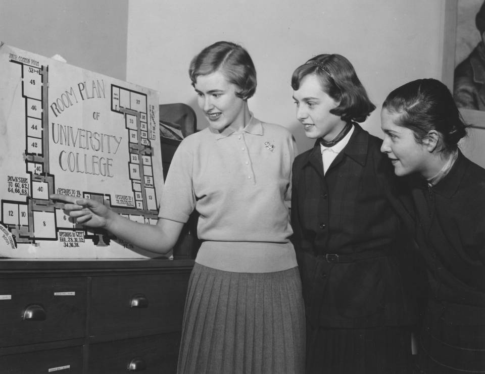 Three young women looking at a "Room Plan for University College"