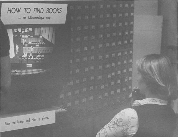 Student holding a telephone receiver and looking at a screen and a sign that says "how to find books: the microcatalogue way; push red button and pick up phone"