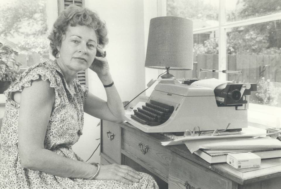 Phyllis Grosskurth seated at desk with typewriter
