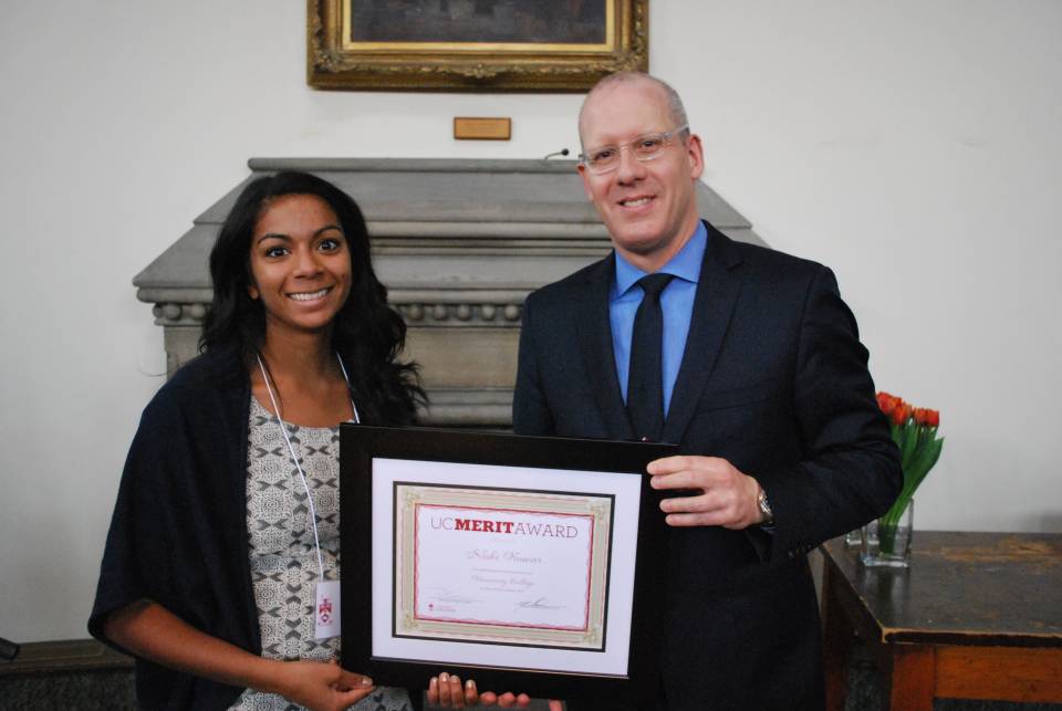 Student holding UC Merit Award Plaque with Principal Donald Ainslie