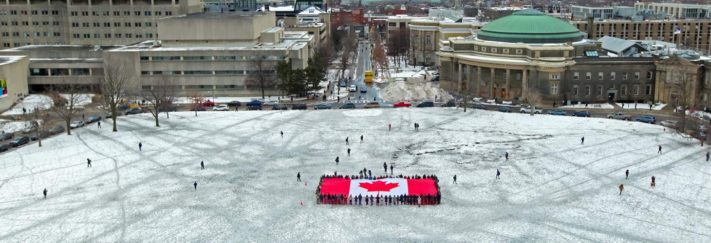 Canadian Flag on snow covered field in front of UC