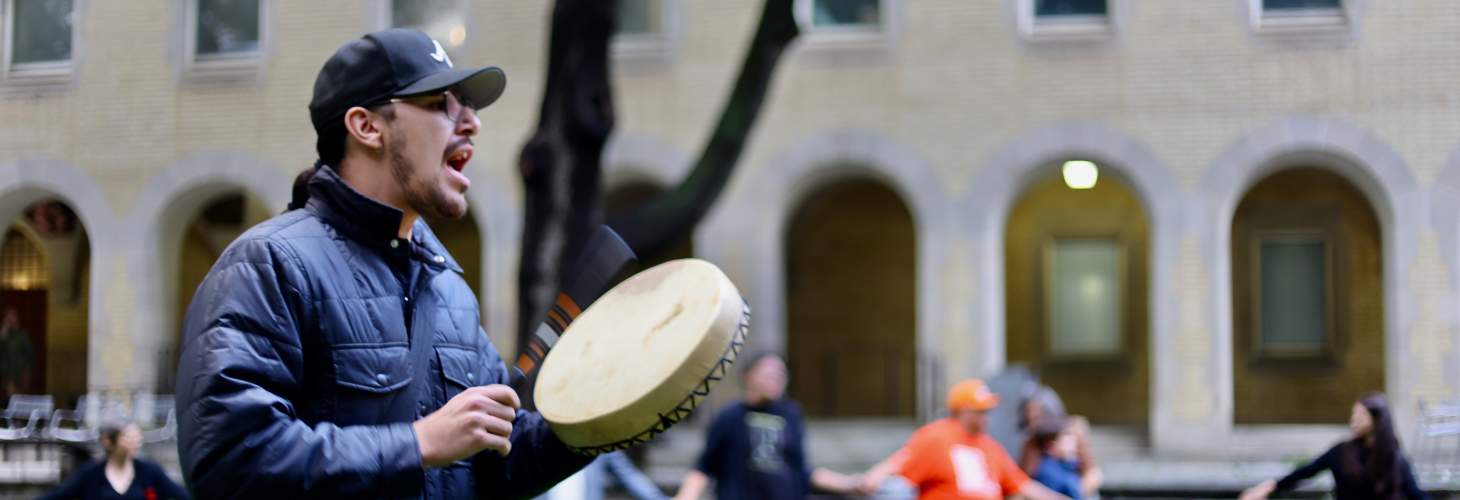 Man beating drum in middle of a round dance