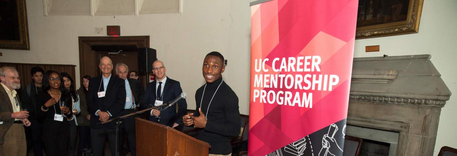 student speaking at a podium during a reception