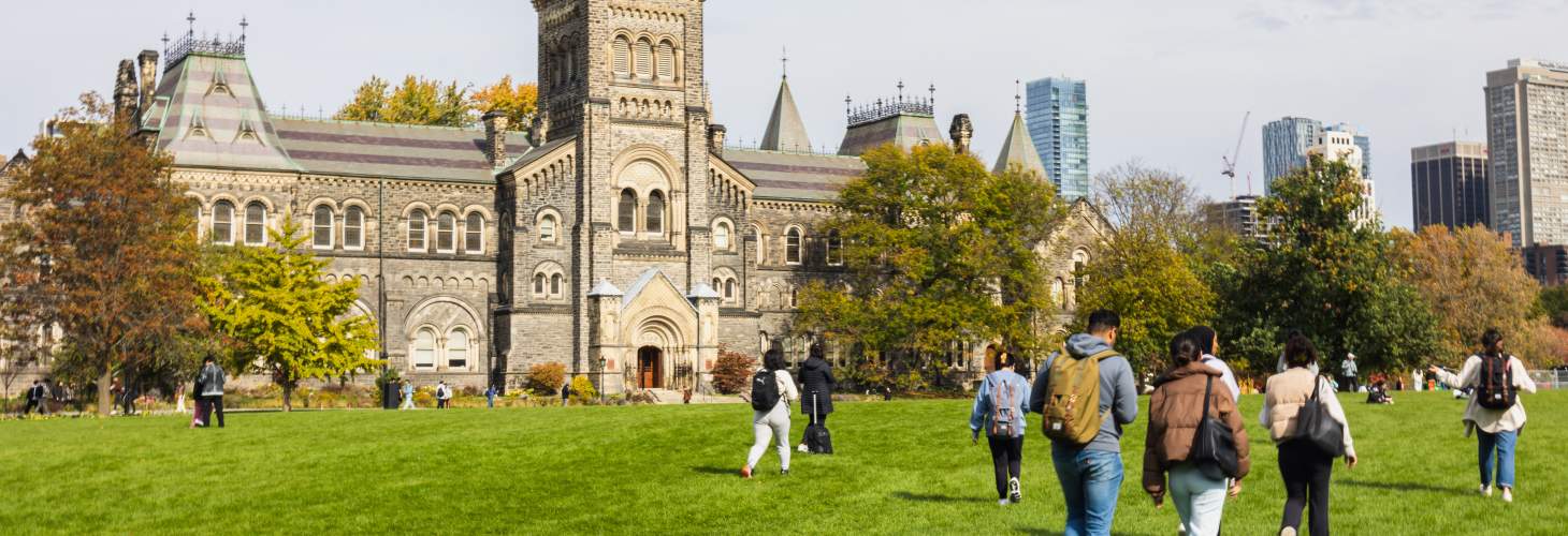 students walking across front campus in front of UC facade