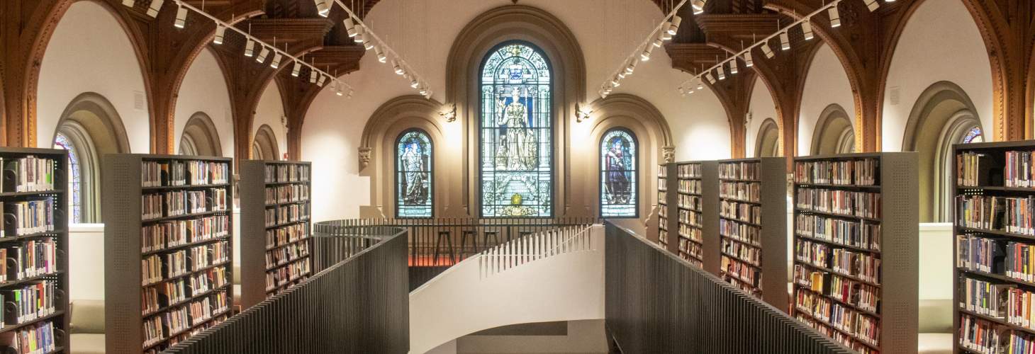 Large library with spiral staircase and stained glass windows