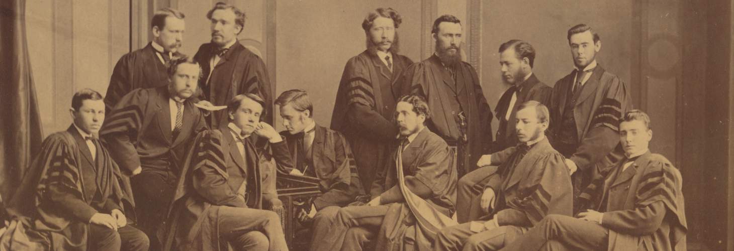 Twelve men in suits and academic robes