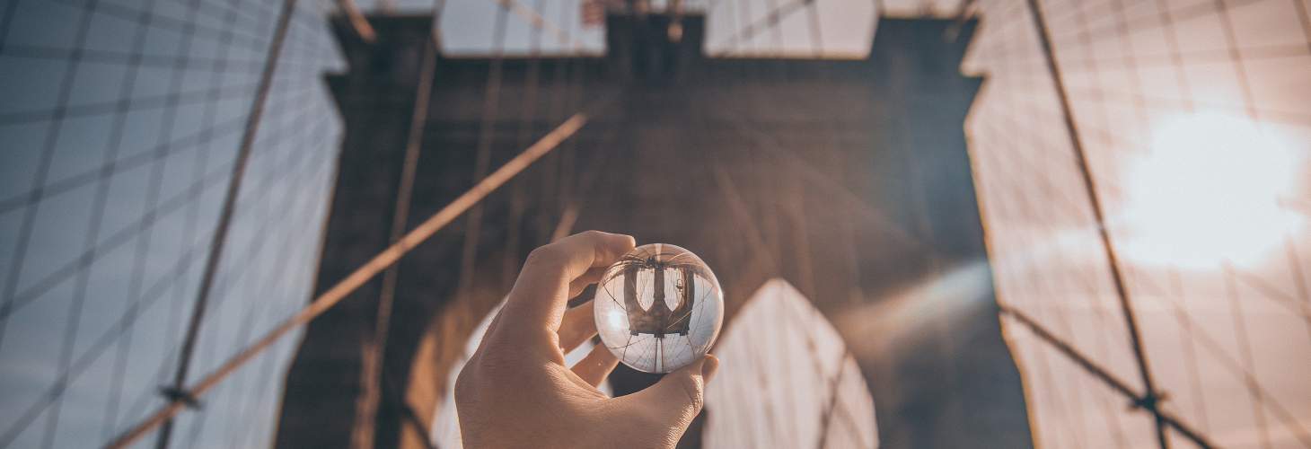 Looking though glass sphere at suspension bridge & sky