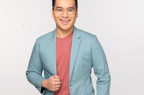 Photo of a smiling student in glasses and powder blue blazer