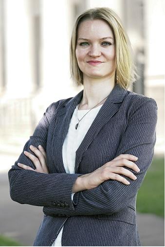 Blonde professor smiling with arms crossed