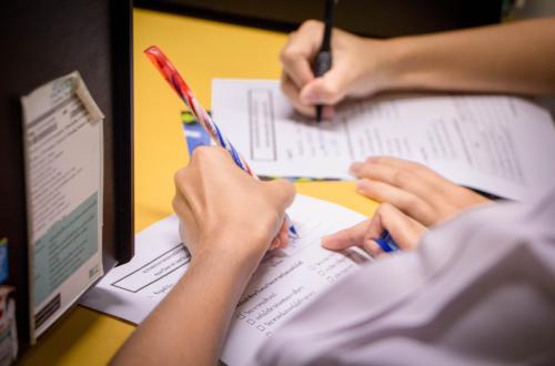 Two students sitting at a table filling out forms