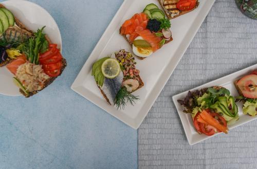 Serving dishes of sliced foods on a white tablecloth