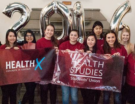 Students holding HealthX banner in front of balloons marked 2016
