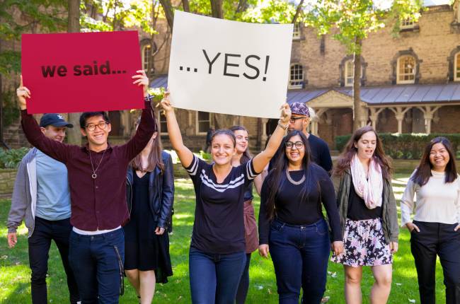 Students holding "We said... Yes" signs