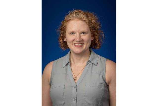 Professional headshot of Emily Atkinson, member of CoRC. She is smiling. 