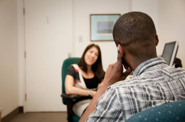 Student sitting in room with an academic advisor for a meeting