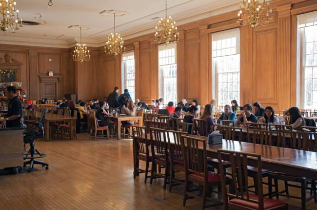 students eating on tables in a dining hall