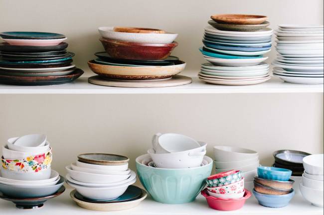 assorted ceramic bowls and saucers on wooden shelves