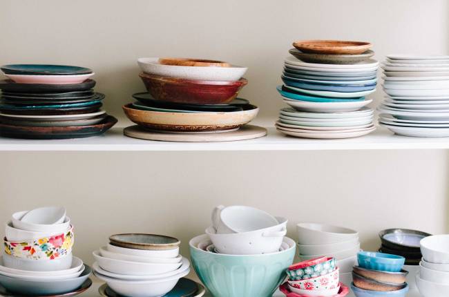 assorted ceramic bowls and saucers on wooden shelves