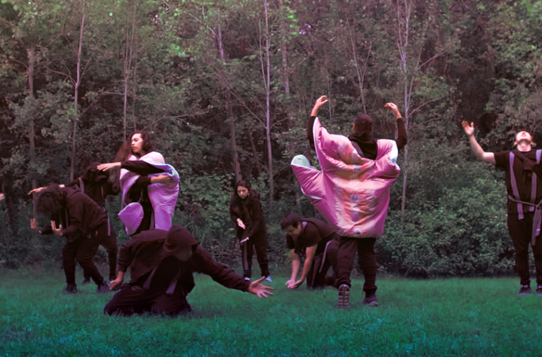 A group of people doing performance art in forest