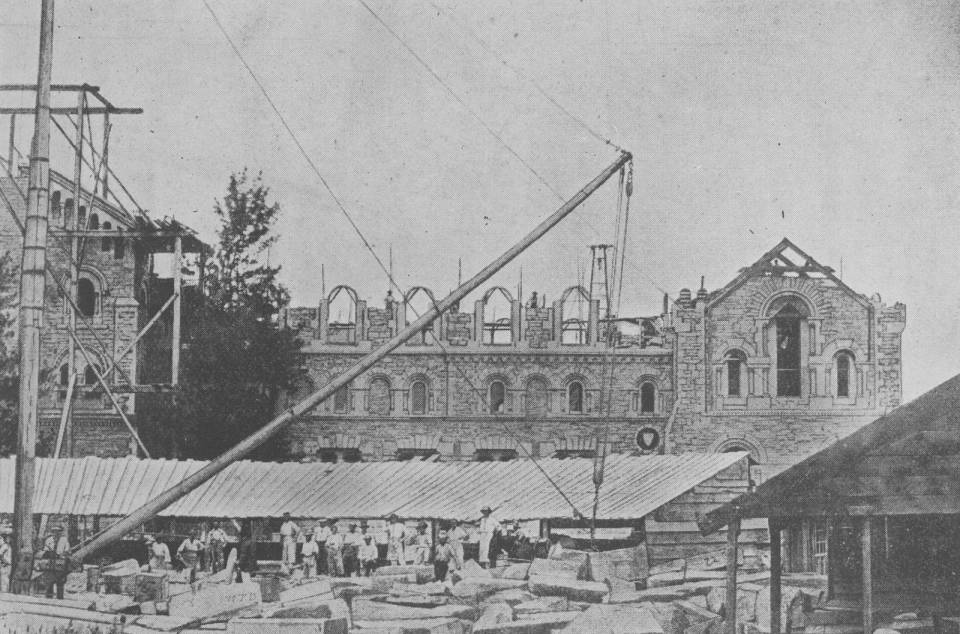 UC exterior under construction with blocks of stone and workers