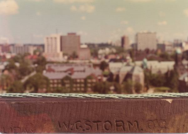 view from roof of University College with words "W.G. STORM", with modern cityscape beyond