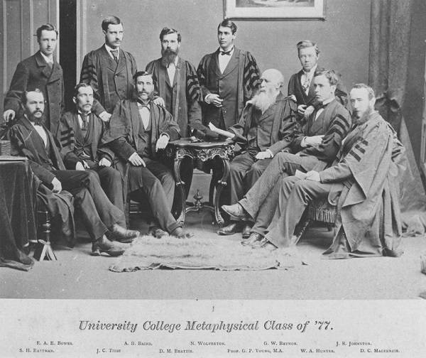 Group of 11 men, most wearing academic robes