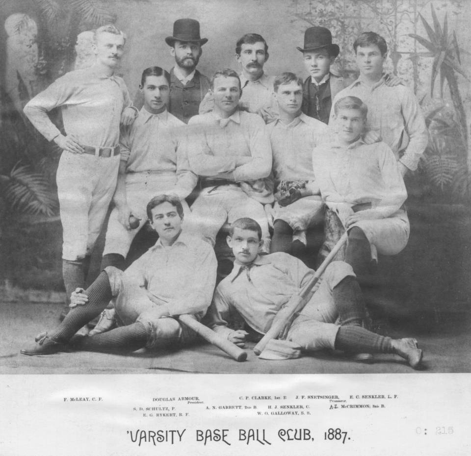 nine men in baseball uniforms and two men in suits