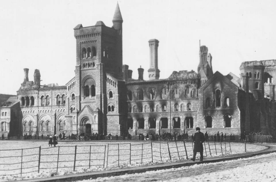 University College damaged by fire, with dozens of people and two horse-drawn carriages in front of the building