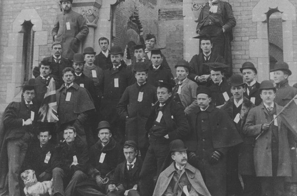 Group of about 30 men, and a small bulldog, in front of University College