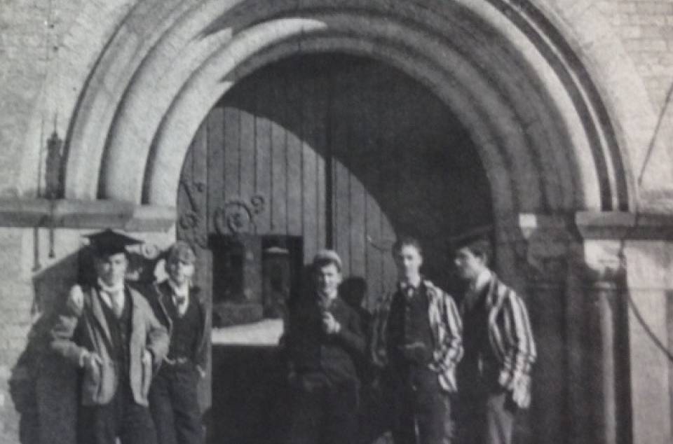 A young William Lyon Mackenzie King with four other young men, standing in front of arched doorway