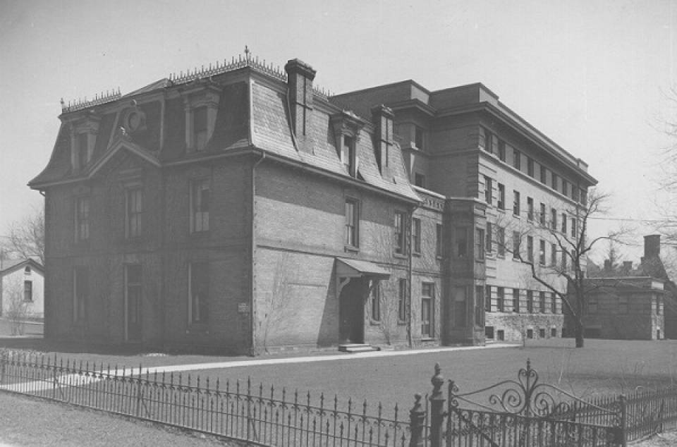 Exterior of building with lawn and wrought iron fence