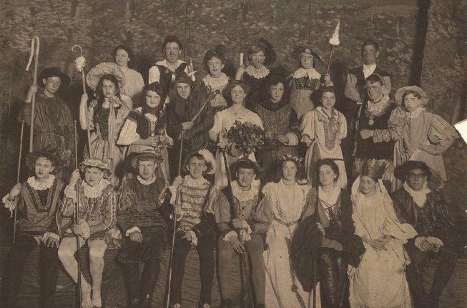 Group portrait of about 25 actors in costume.