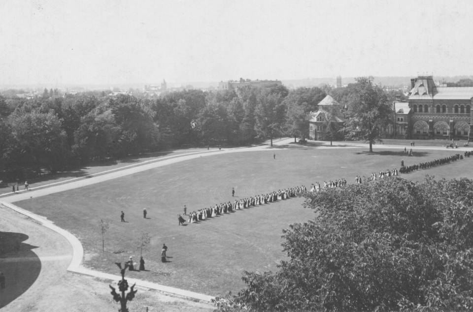 aerial view of Front Campus showing over 100 people in academic robes walking from University College to Convocation Hall