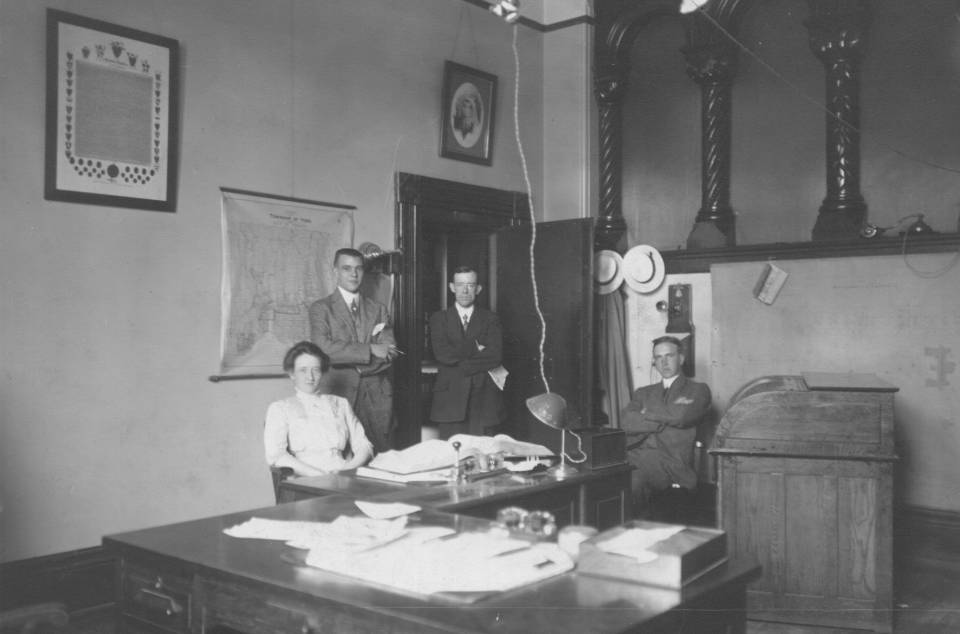 one woman and three men in an office