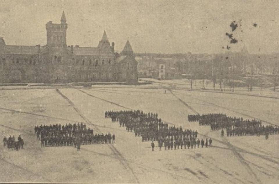 Distant view of rows of soldiers with University College in background