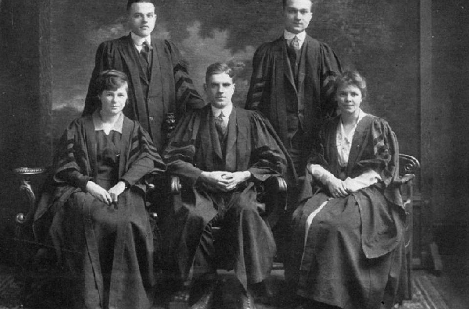 group portrait of three men and two women in academic robes