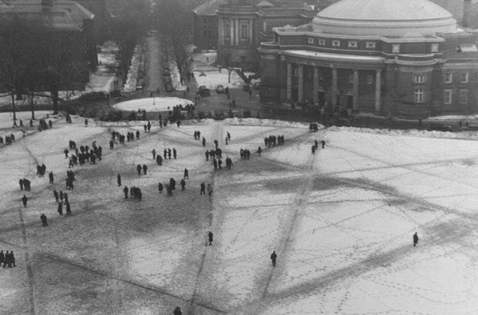 Aerial view of many people crossing front campus, with Convocation Hall in the background