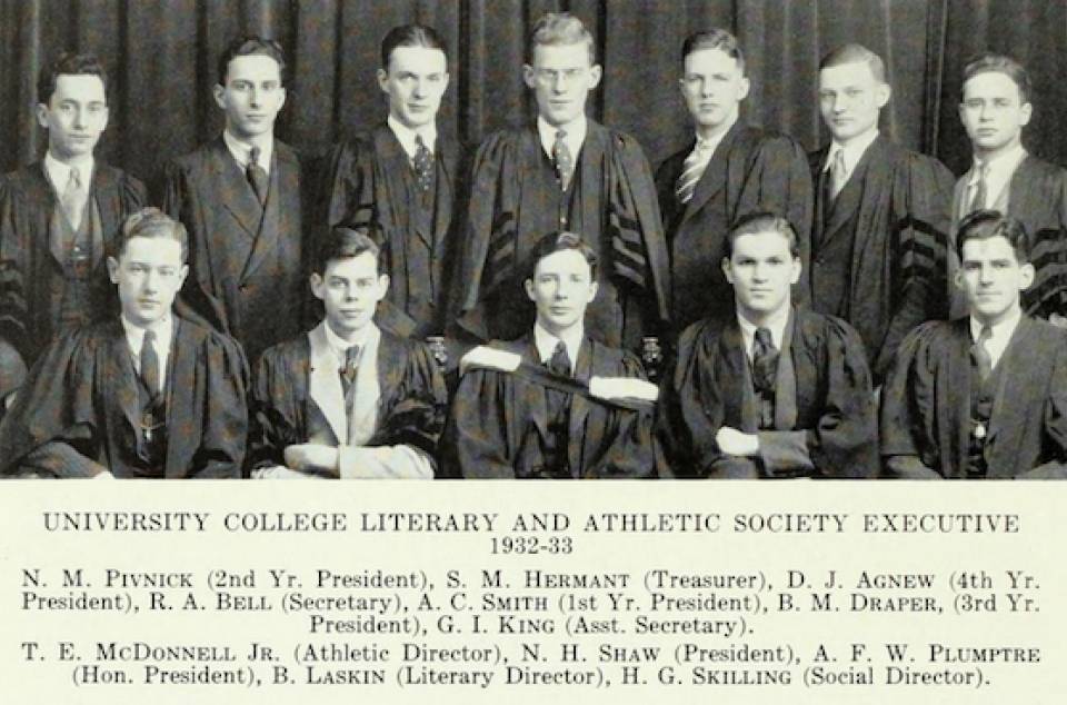 Twelve men in suits and academic robes