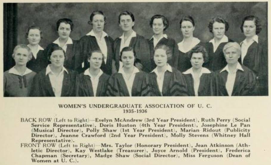 Thirteen young women in academic robes with two older women
