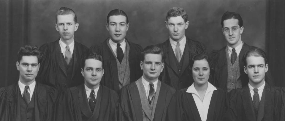 Eight men and one woman in academic robes