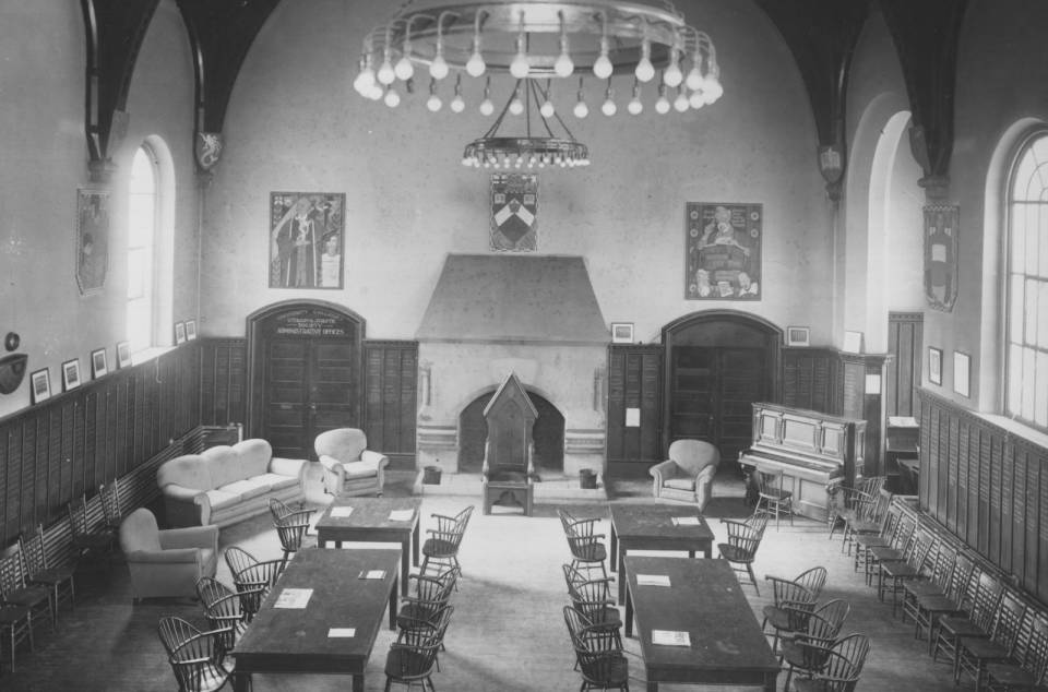 room with tables, chairs, a fireplace, and large windows