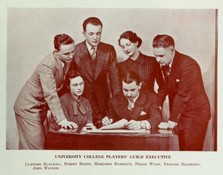 four men and two women around a desk with caption "University College Players' Guild Executive"