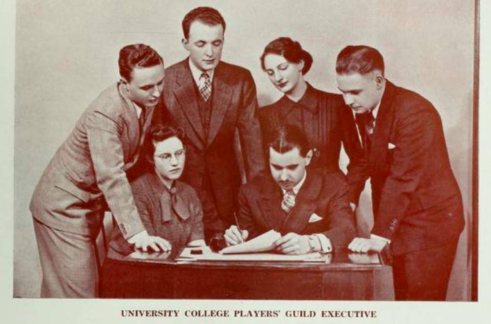 four men and two women around a desk with caption "University College Players' Guild Executive"