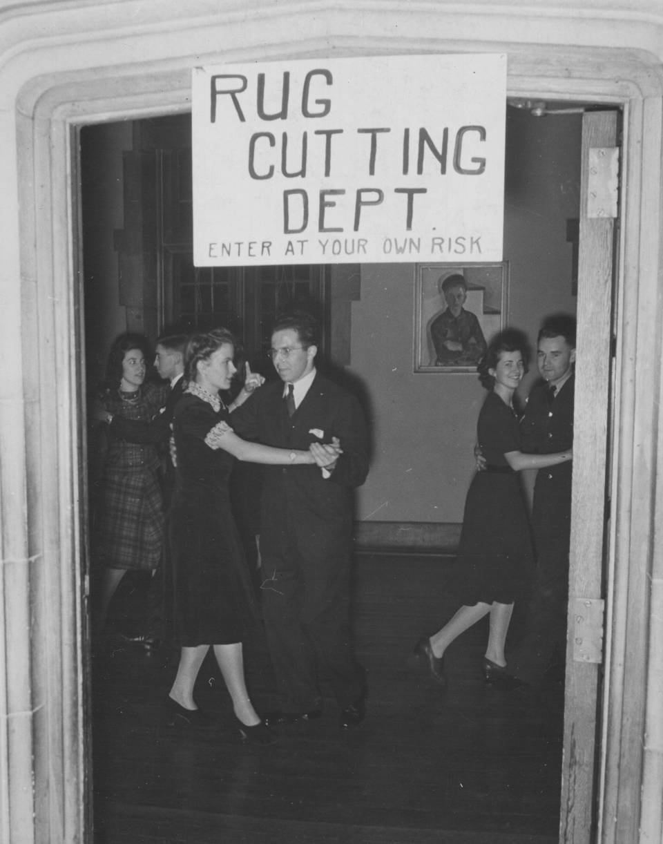 Three couples dancing under a handwritten sign that says "Rug Cutting Dept. Enter at your own risk"