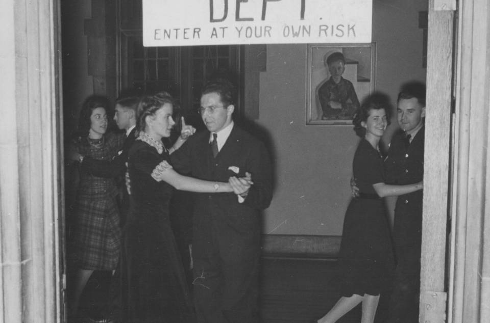 Three couples dancing under a handwritten sign that says "Rug Cutting Dept. Enter at your own risk"